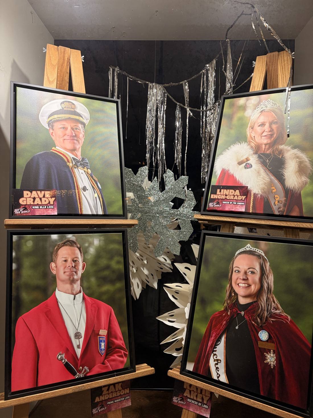 Framed portraits of the 2026 Winter Carnival royal court on display in a downtown window